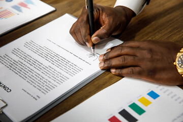 Close up and selective focus on African black formal professional business male hands holding pen,...