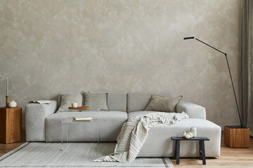 Creative composition of stylish japandi living room with grey sofa, wooden cubes and small personal...