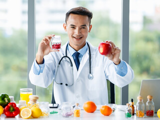 Male nutritionist with fruit and pills in medical office