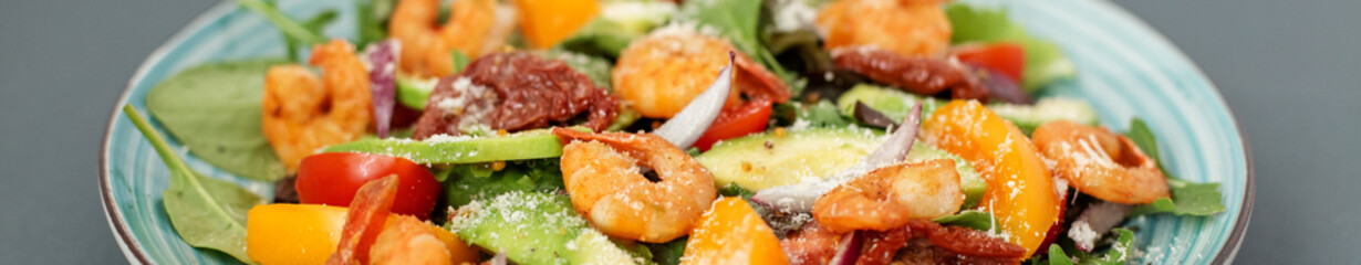 Banner Fresh salad plate with shrimp, tomato and mixed greens (arugula, mesclun, mache) on wooden background close up. Healthy food. Clean eating.