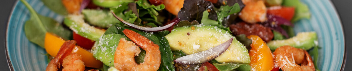 Banner Fresh salad plate with shrimp, tomato and mixed greens (arugula, mesclun, mache) on wooden background close up. Healthy food. Clean eating.