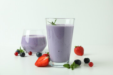 Glasses of smoothie and ingredients on white background