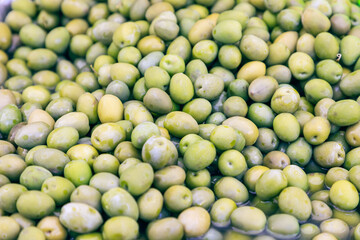 Green pickled olives with red peppers at a grocery market in italy