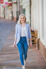 Portrait of a beautiful young woman in a European city. Makes purchases. Tourism. Summer.