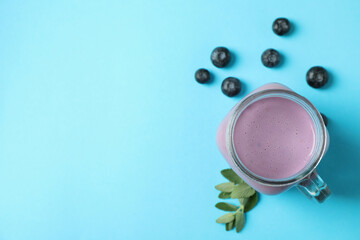 Fresh blueberry smoothie and ingredients on blue background