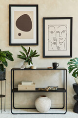Creative composition of stylish modern living room interior with two mock up poster frames, black geometric commode, leaf in vase and personal accessories. Neutral colors. Template.