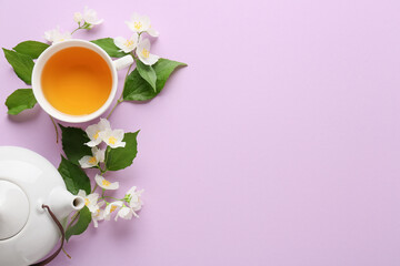 Composition with cup of jasmine tea, teapot and flowers on color background