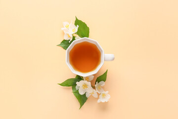 Obraz na płótnie Canvas Cup of jasmine tea and flowers on color background