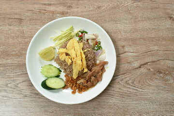 rice mixed with shrimp paste topping slice Thai egg omelette couple sweet pork in gravy and vegetable on plate