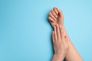 Hands with beautiful manicure on color background