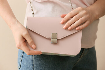 Woman with beautiful manicure and bag on color background, closeup