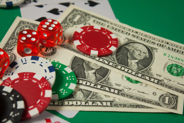 Classic playing cards, chips, red dice and dollars on green background. Gambling and casino concept.