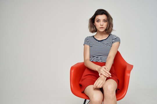woman sitting on red chair basing fashion modern style