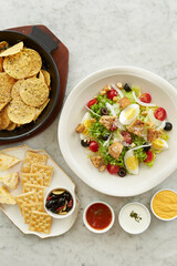 Vegetable salad with nacho chips and sauces