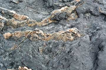 Black volcanic stone texture with abstract pattern, close-up