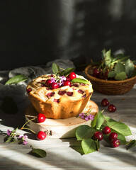 Summer cake with cherries on a wooden table. Homemade tea party, the sun is shining outside the window. Sweet dessert for the family