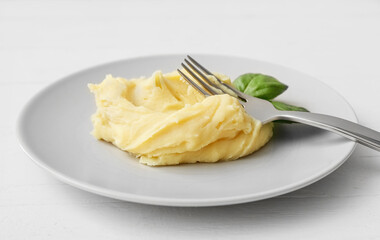 Plate with tasty mashed potatoes on light wooden background, closeup
