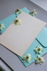 Minimalistic card mockup with white flowers, flower, craft envelope, blossom, flat lay, top view