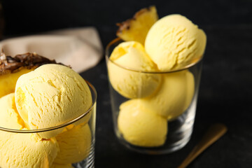 Glasses with tasty pineapple ice cream on dark background, closeup