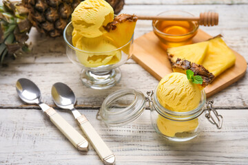 Composition with tasty pineapple ice cream and honey on light wooden background