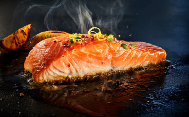 Gourmet portion of thick juicy salmon grilling on a griddle - 447663164
