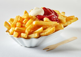 Delicious French fries with ketchup and mayo in ceramic bowl