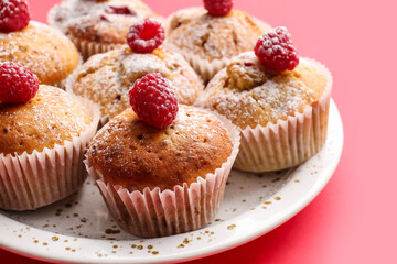 Plate with tasty raspberry muffins on color background, closeup