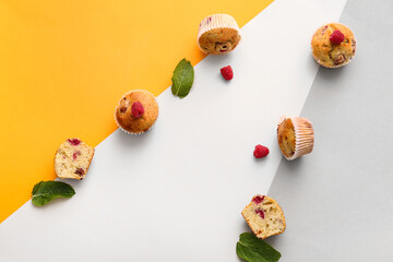 Tasty raspberry muffins on color background