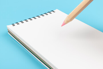 Blank paper and pencil on a blue background