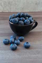 small bowl full of blueberries and some blueberries on a wooden table