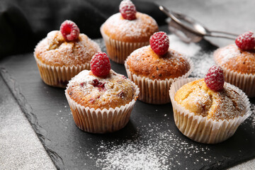 Board with tasty raspberry muffins on table