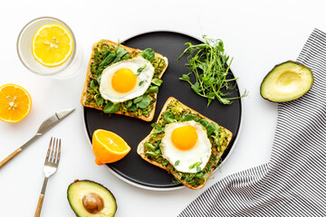 Toasts with avocado and fried eggs. Healthy breakfast