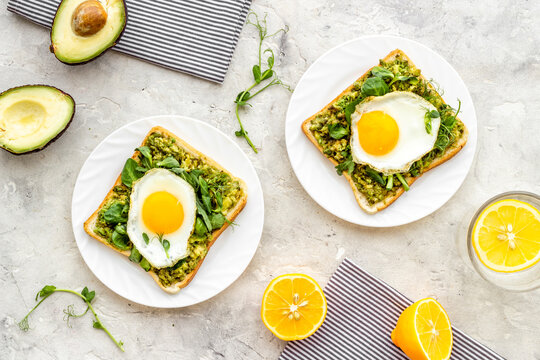 Breakfast with toasts of fried eggs and avocado saurce. Top view
