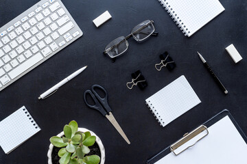 Office desk table with equipment - computer keyboard and notepad, top view