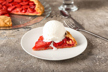 Plate of tasty strawberry pie decorated with ice cream on grunge background