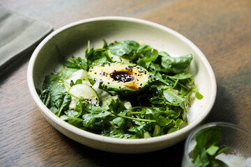 Healthy green salad with avocado and sesame dressing