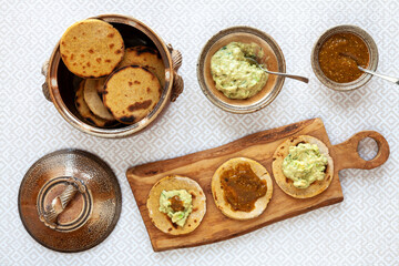 Avocado with tahini and greek yogurt sauce with roasted tomatillo salsa on corn roti flatbread.