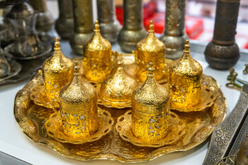 Fototapeta na wymiar Turkish oriental, traditional antique gold decorated ethnic coffee cups and decorative gift cups with a cap on Arabic style.
