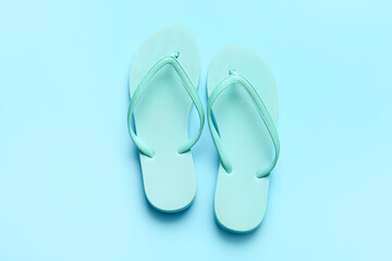 Stylish flip-flops on color background
