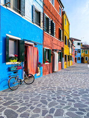 Bike placed on the facade of a multicolored house in Burano island, Venice