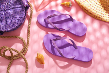Stylish flip-flops and bag on color background