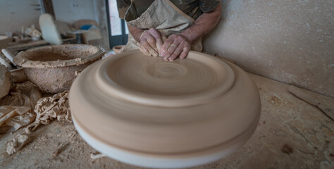 Potter hands working on pot closeup view