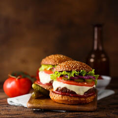 Traditional homemade cheeseburgers with pickles