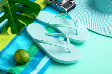 Set of beach accessories with flip-flops on color background