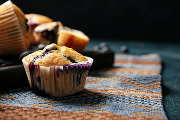 Tasty blueberry muffins on table, closeup
