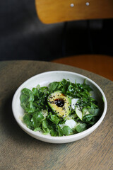 Healthy green salad with avocado and sesame dressing	