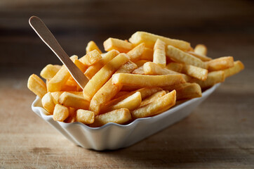 Tasty French fries with eco stick in ceramic bowl