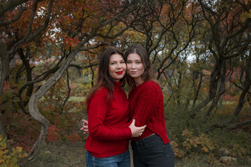 Fototapeta premium Mature mother hugging with her teen daughter outdoor in nature