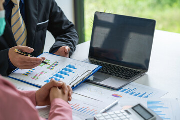 Marketers and conference leaders on business plans and marketing strategies using laptops for data analysis Using business data graphs in meetings. Business brainstorming,