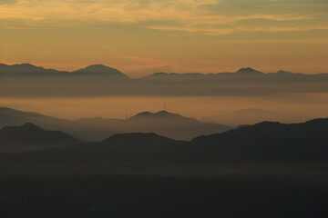 朝日が昇る前の霧が漂う山